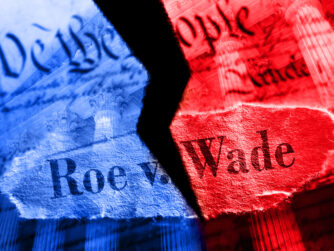 The constitution ripped in two. One side colored red the other blue. With the words Roe v. Wade superimposed over the image.