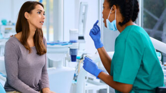 Female dentist and female patient talking in a dental office.