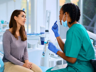 Female dentist and female patient talking in a dental office.